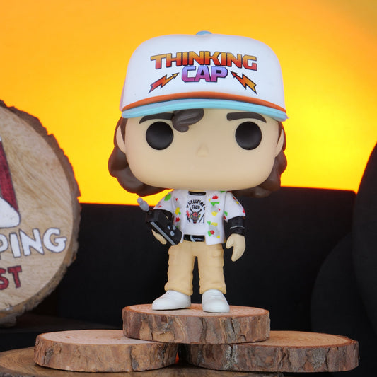 Funko Pop! Stranger Things Dustin vinyl figure on a wooden stand with 'Shopping Nest' branding.
