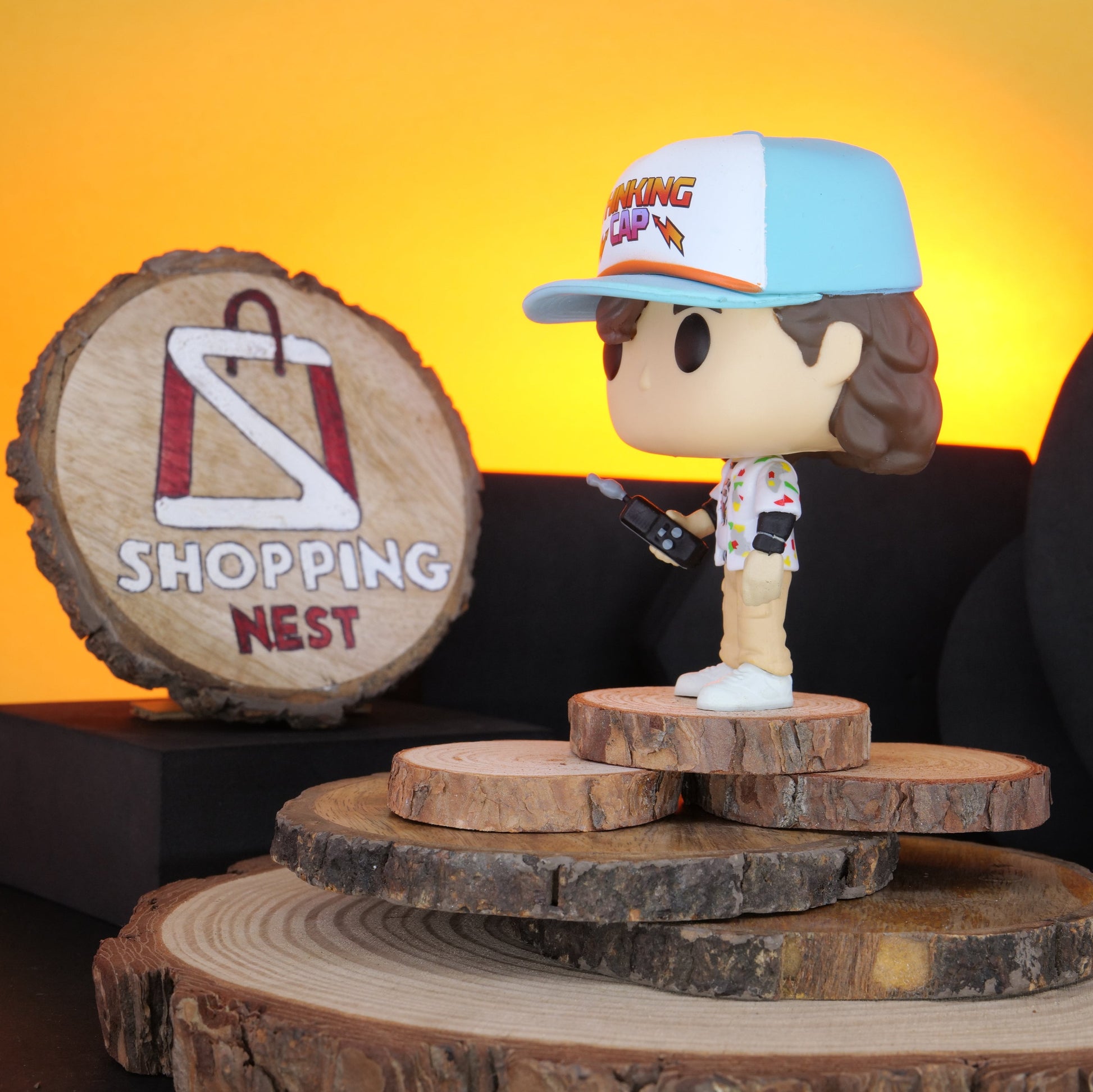 Funko Pop! Stranger Things Dustin vinyl figure on a wooden stand with 'Shopping Nest' branding.RIGHT SIDE
