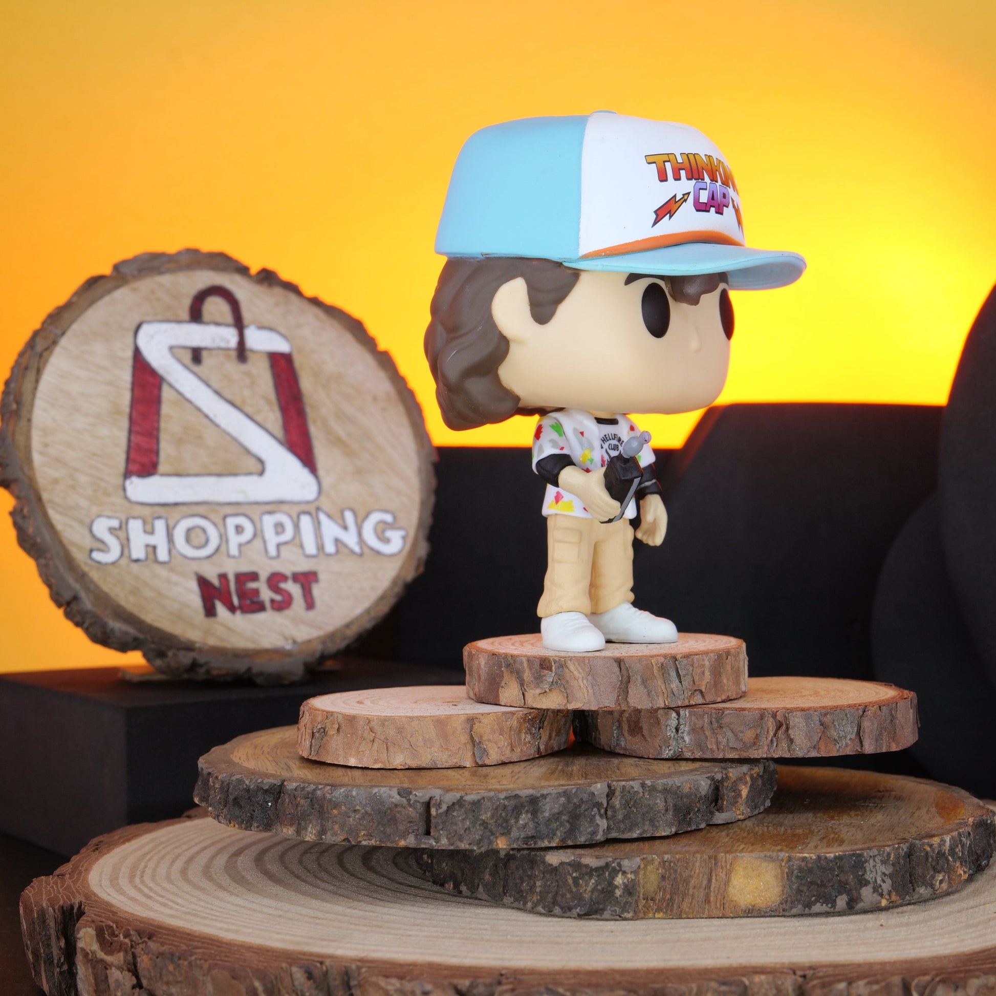 Funko Pop! Stranger Things Dustin vinyl figure on a wooden stand with 'Shopping Nest' branding.