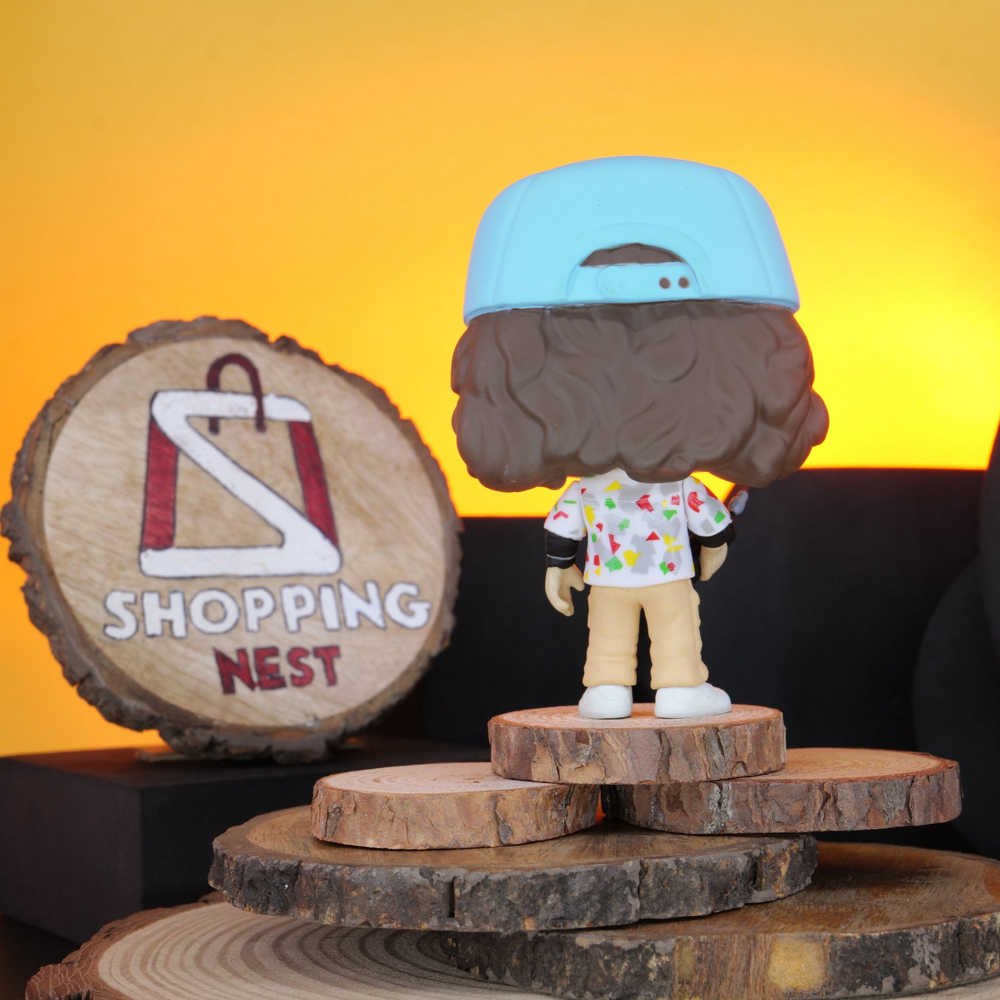 Funko Pop! Stranger Things Dustin vinyl figure on a wooden stand with 'Shopping Nest' branding.