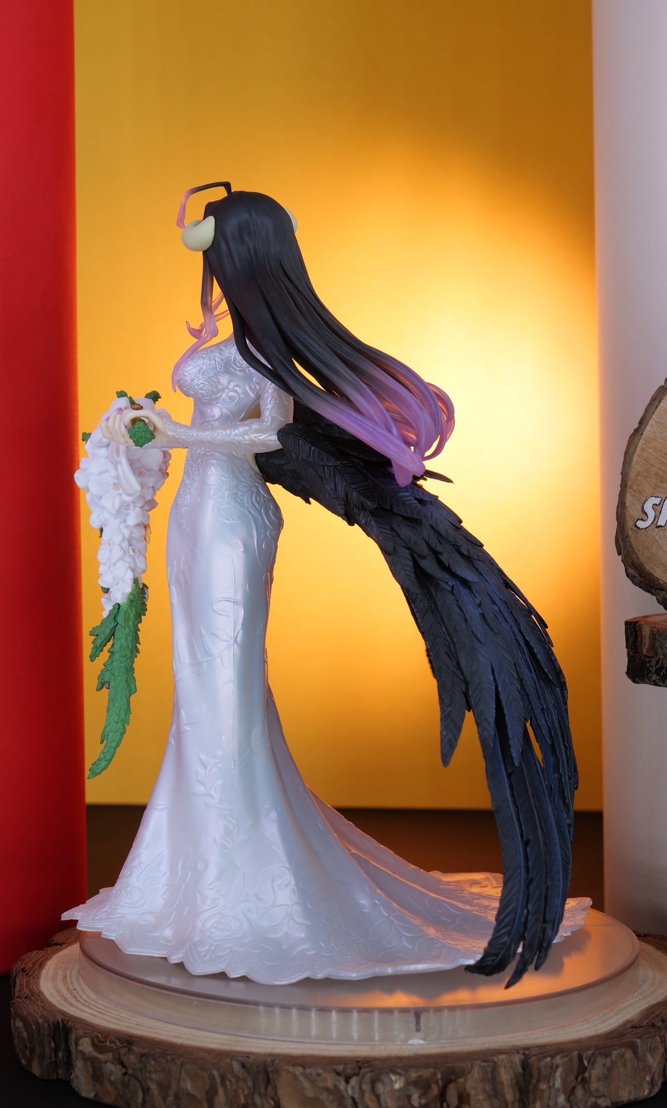 Figurine of a character in a white dress with long black hair against a colorful background